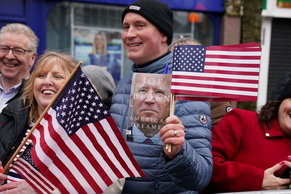People hold flags as U.S. President Joe Biden visits Dundalk, Ireland, April 12, 2023. REUTERS/Kevin Lamarque