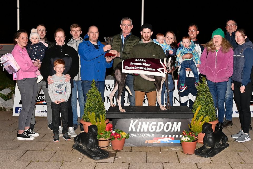 Fonz Murphy accepts the winner's trophy from Brendan Maunsell (K.G.O.B.A chairman) alongside winning trainer and owner Michael Murphy, with Alannah Daly and sons Zach and Jaden Murphy, Patrick Murphy, KGS Racing Manager Kieran Casey, and family connections after Leahys Sysco won the K.G.O.B.A. A5 Stake Final at the Kingdom Greyhound Stadium on Friday night. Photo by www.deniswalshphotography.com