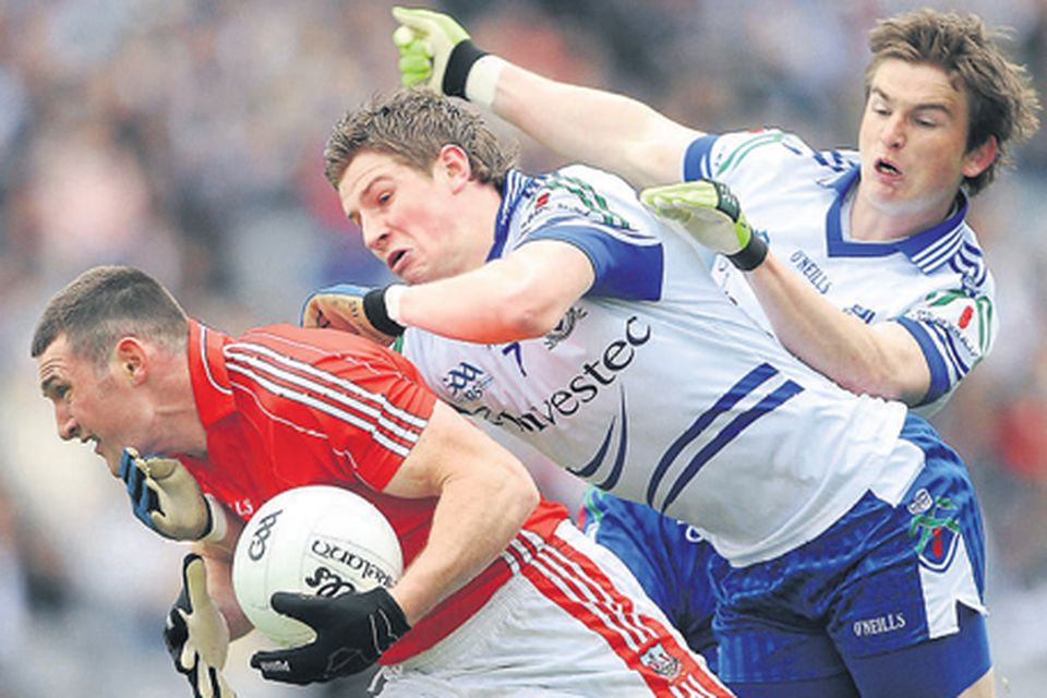 Cork’s Noel O'Leary is tackled by Monaghan's Darren Hughes and
Dessie Mone while, left, O'Leary competes with Kieran Hughes for a high ball