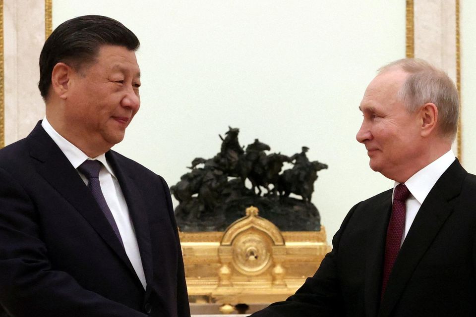 Vladimir Putin shakes hands with Xi Jinping during a meeting at the Kremlin yesterday. Photo: Sergei Karpukhin