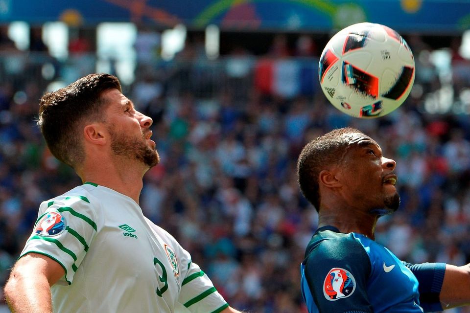 Shane Long of Republic of Ireland challenges Patrice Evra of France during the UEFA Euro 2016 Round of 16 match between France and Republic of Ireland at Stade des Lumieres in Lyon