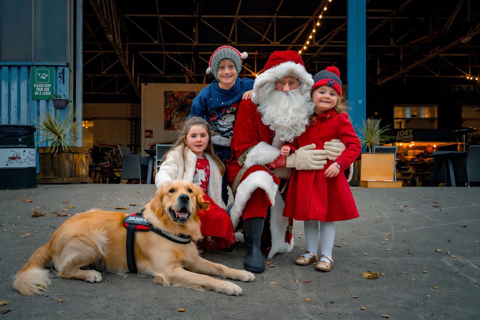 Ciara Murphy (5), Cillian Buckley (9) and Fiadh Murphy (4) pictured with Santa Claus and Rocket the dog in the Marina Market, Cork. Pic: Chani Anderson