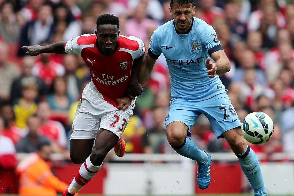Arsenal's Danny Welbeck tussles with Manchester City's Martin Demichelis during the Barclays Premier League match at the Emirates Stadium, London