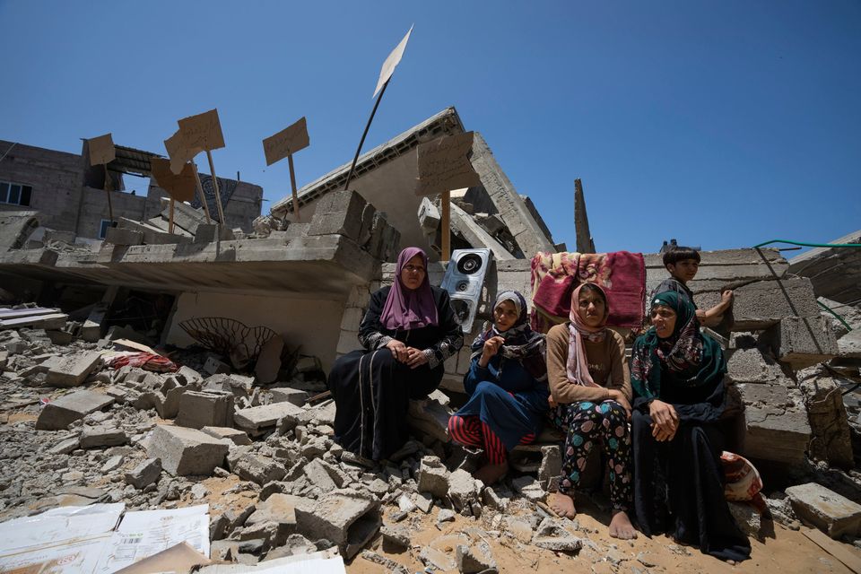 Family members sit in front of the ruins of their home, which was destroyed in an Israeli airstrike in Jabaliya, northern Gaza Strip. Photo: Fatima Shbair/AP