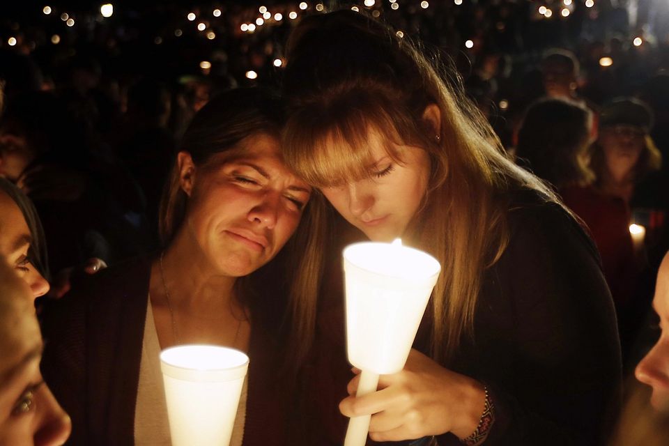 Kristen Sterner, left, and Carrissa Welding, students of Umpqua Community College, embrace each other during a vigil for those killed at the college (AP)
