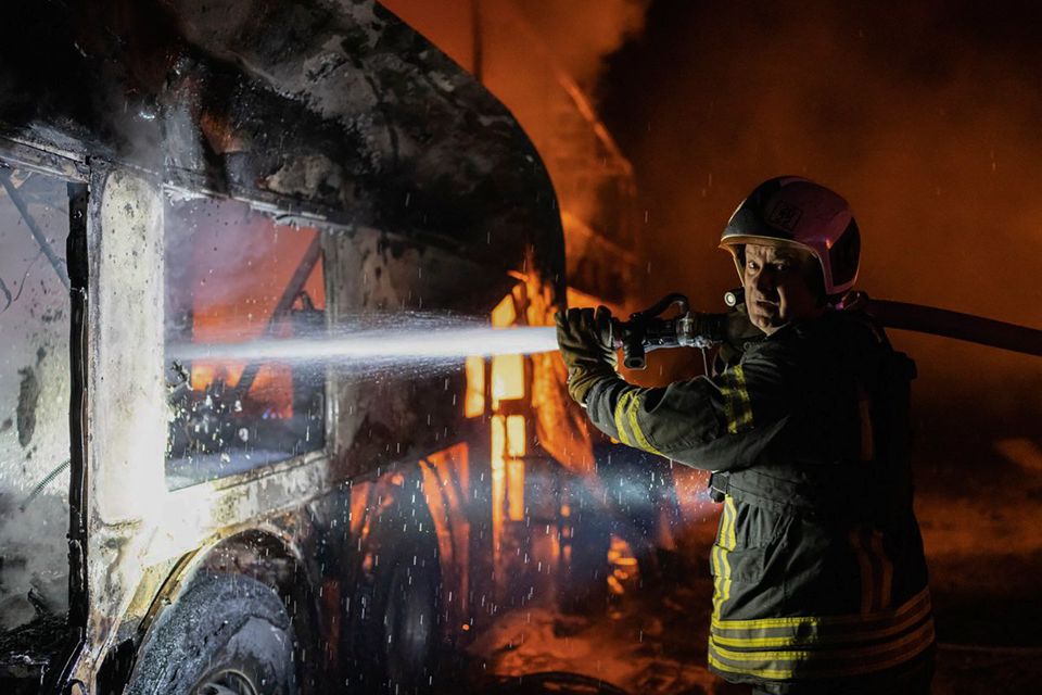 A Ukrainian firefighter puts out fire caused by fragments of a Russian rocket shot down in Kyiv. Photo: Ukrainian Emergency Situations Ministry via AP