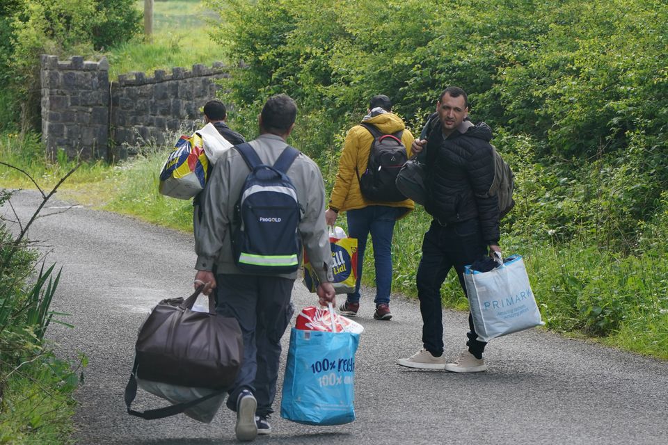 Asylum-seekers leaving the grounds of the Magowna House hotel in Inch, Co Clare, last week after a blockade by local people. Photo: Niall Carson/PA