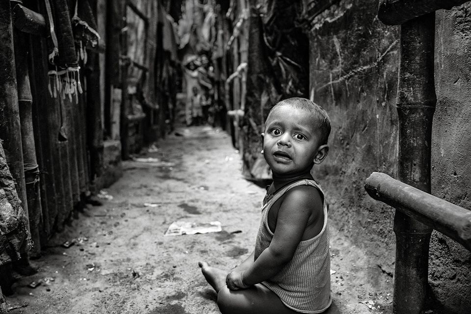 A young child playing on his own near his home in Chitpur slum in Kolkata, India. Photo: Arthur Carron
