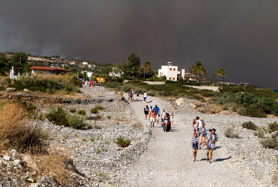 Tourists are evacuated as wildfires burn near Lindos, on the island of Rhodes. Photo: Reuters