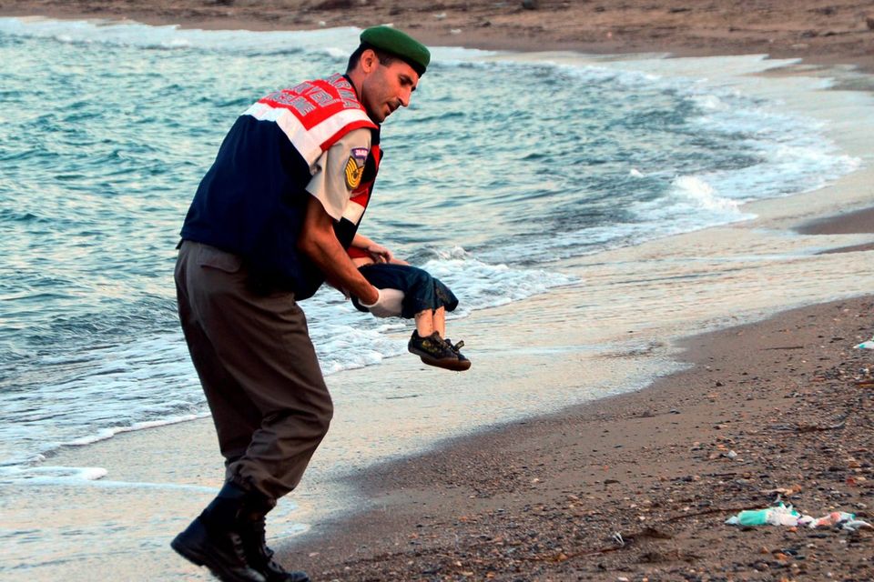 A Turkish border guard carries the lifeless body of Aylan Kurdi (3) after a number of migrants died and others were reported missing when boats carrying them to the Greek island of Kos capsized near Bodrum in Turkey.