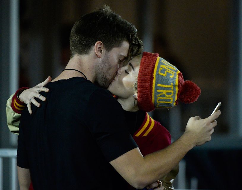 Miley Cyrus  kisses Patrick Schwarzenegger during the game between the California Golden Bears and the USC Trojans at Los Angeles Memorial Coliseum on November 13, 2014 in Los Angeles, California.