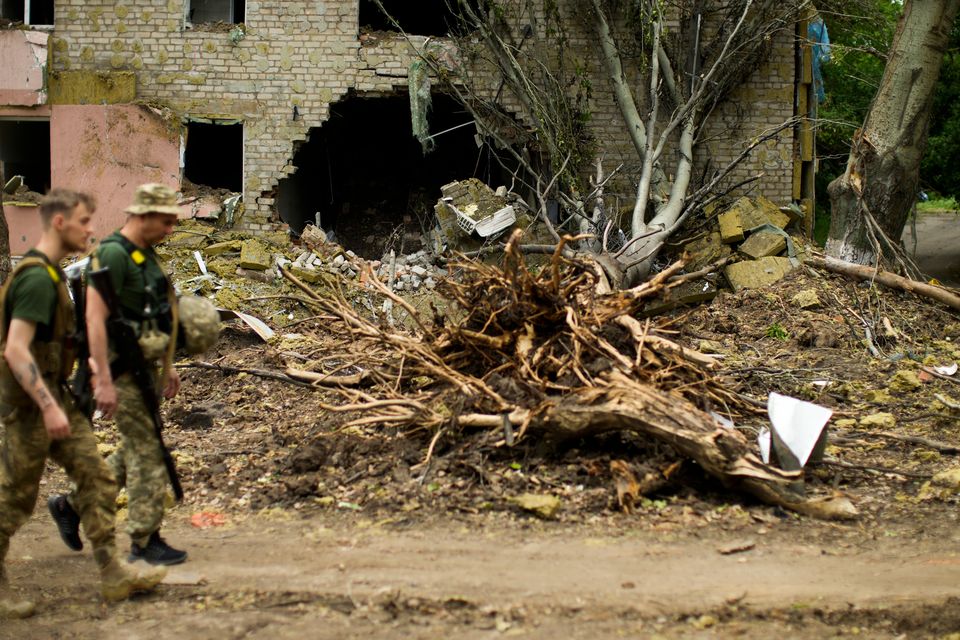 Ukrainian servicemen walk past a building heavily damaged in a Russian bombing in Bakhmut, eastern Ukraine, eastern Ukraine, Saturday, May 28, 2022. Fighting has raged around Lysychansk and neighbouring Sievierodonetsk, the last major cities under Ukrainian control in Luhansk region. (AP Photo/Francisco Seco)
