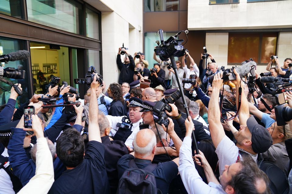 Photographers surround Russell Brand as he arrives at court (James Manning/PA)
