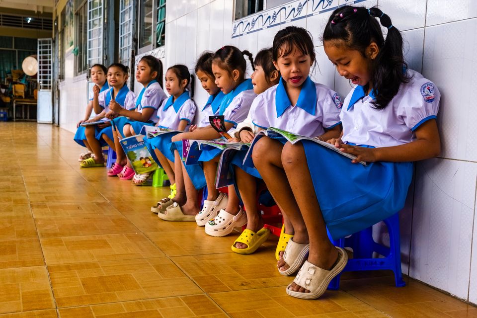 School children sit in the courtyard of a school in the village of Tan Thoi, Vietnam. Photo: Getty