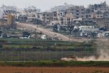 thumbnail: A tank maneuvers near the Israel-Gaza border on the Israeli side as people walk inside Gaza, amid the ongoing conflict between Israel and the Palestinian Islamist group Hamas, as seen from Israel, March 17, 2024. REUTERS/Amir Cohen TPX IMAGES OF THE DAY