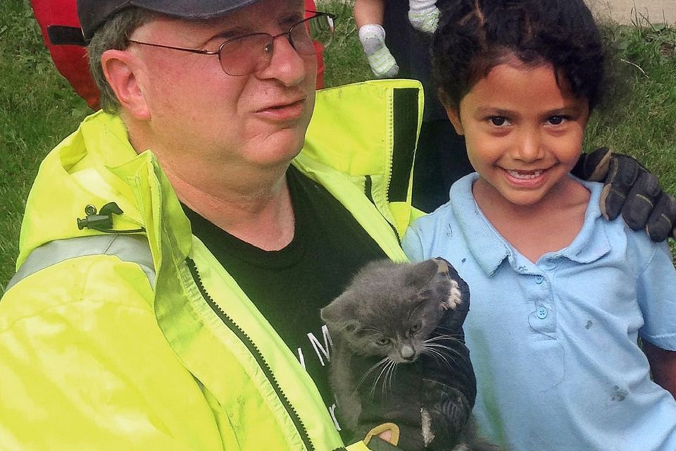 Lancaster Township Fire Department Deputy Fire Chief Glenn Usdin holds the kitten rescued with the help of six-year-old Janeysha Cruz (AP/Lancaster Township Fire Department)