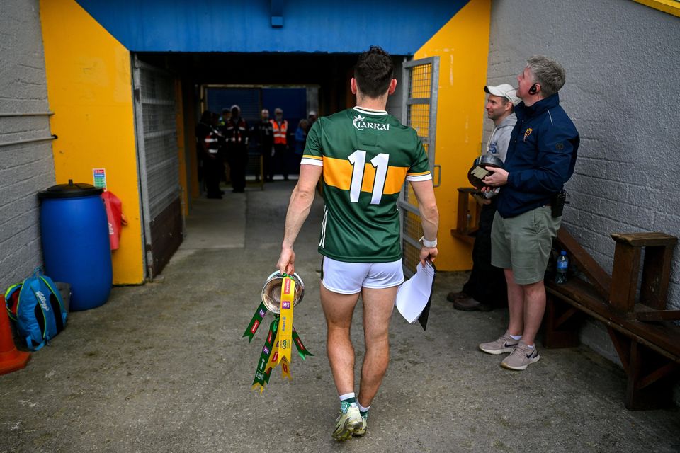 Kerry captain Paudie Clifford makes his way back to the dressing-room with the cup after his team's win over Clare in the Munster SFC final at Cusack Park in Ennis. Photo by Sportsfile