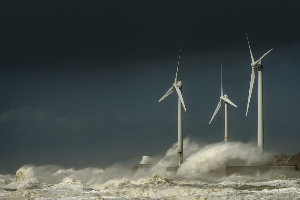 Three wind turbines amidst fierce waves near Calais, France. Photo: Getty