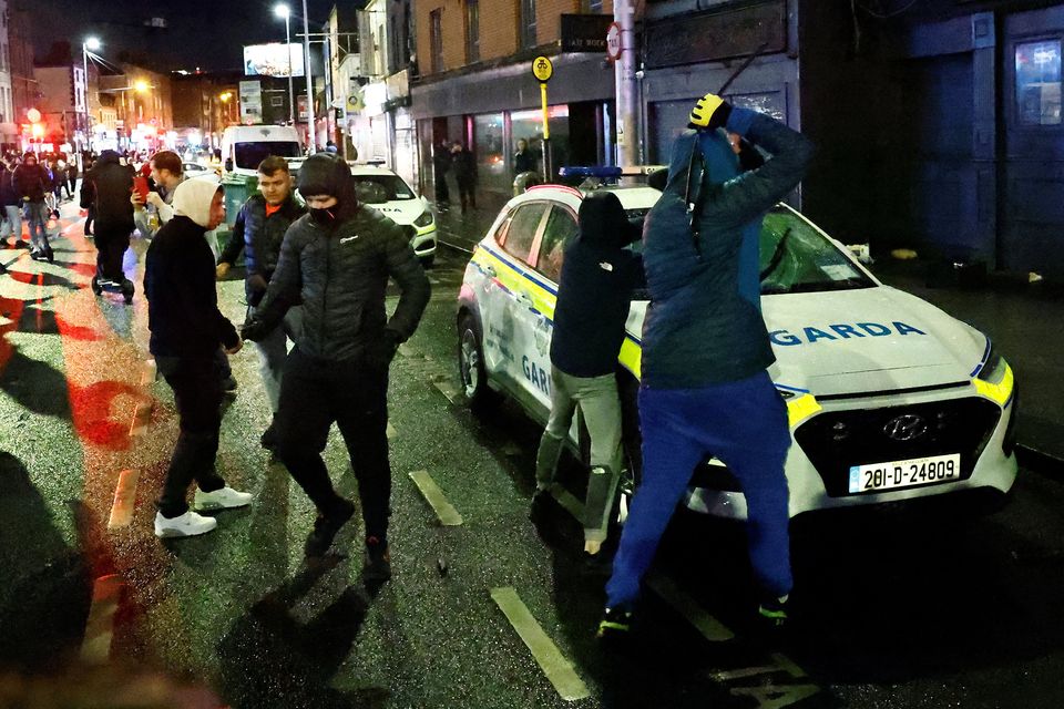 Thugs vandalise a garda vehicle near the scene of the stabbings in Parnell Square. Photo: Clodagh Kilcoyne/Reuters