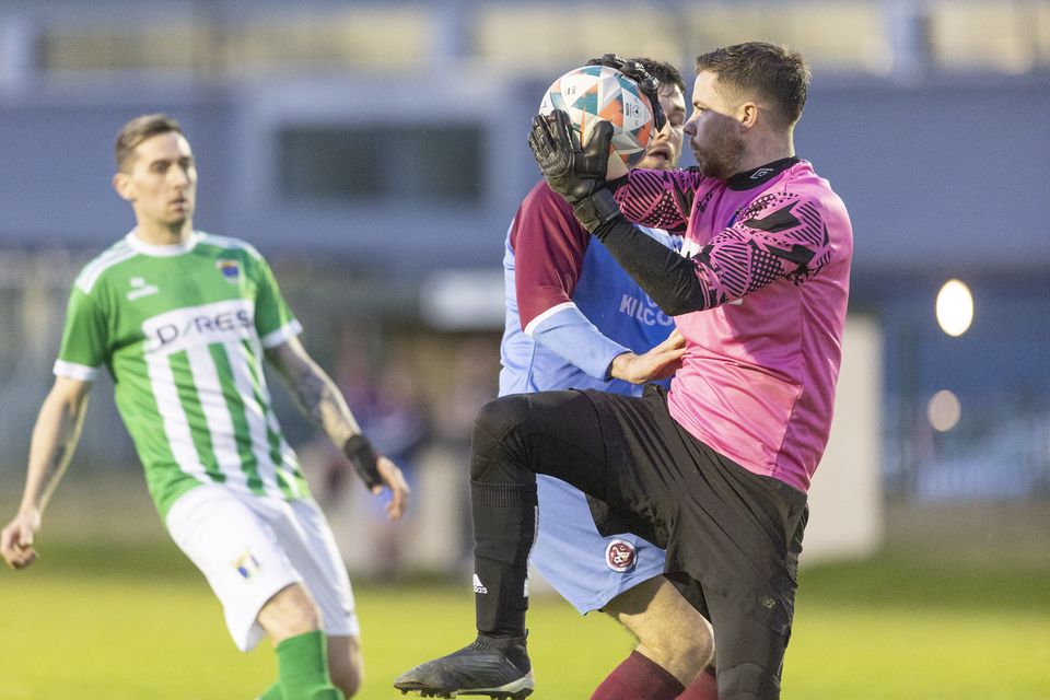 Wicklow Rovers goalkeeper James Kavanagh takes the ball from the head of Shane Doyle of St. Anthony's.