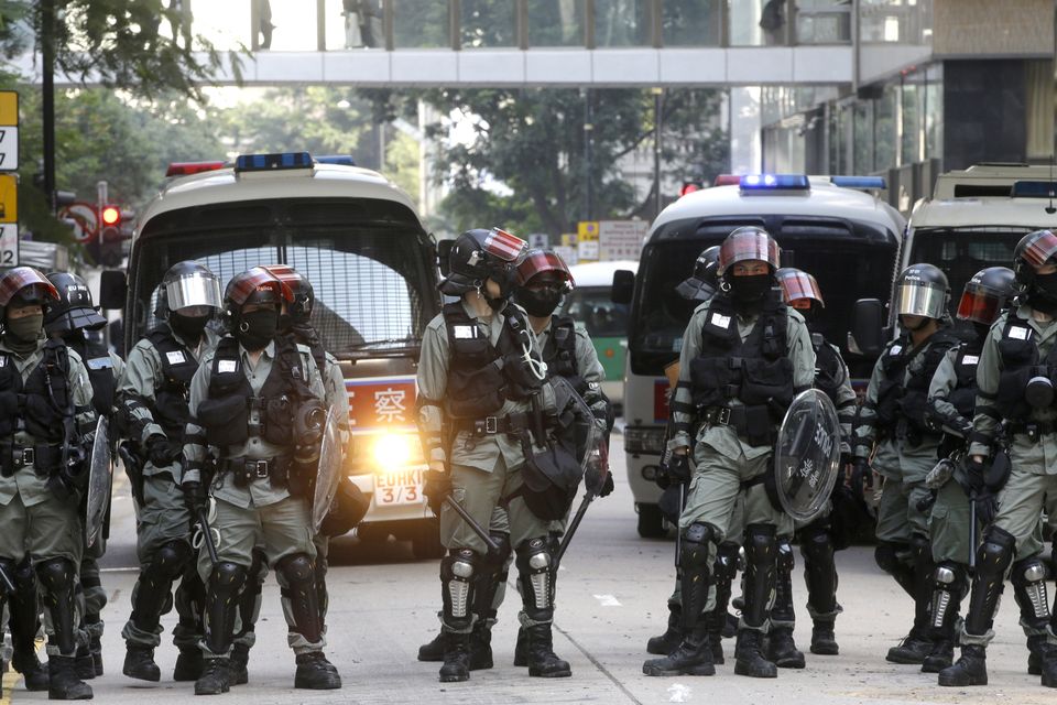 Police in riot gear arrive at the scene of a protest in the financial district in Hong Kong on Friday (Achmad Ibrahim/AP)