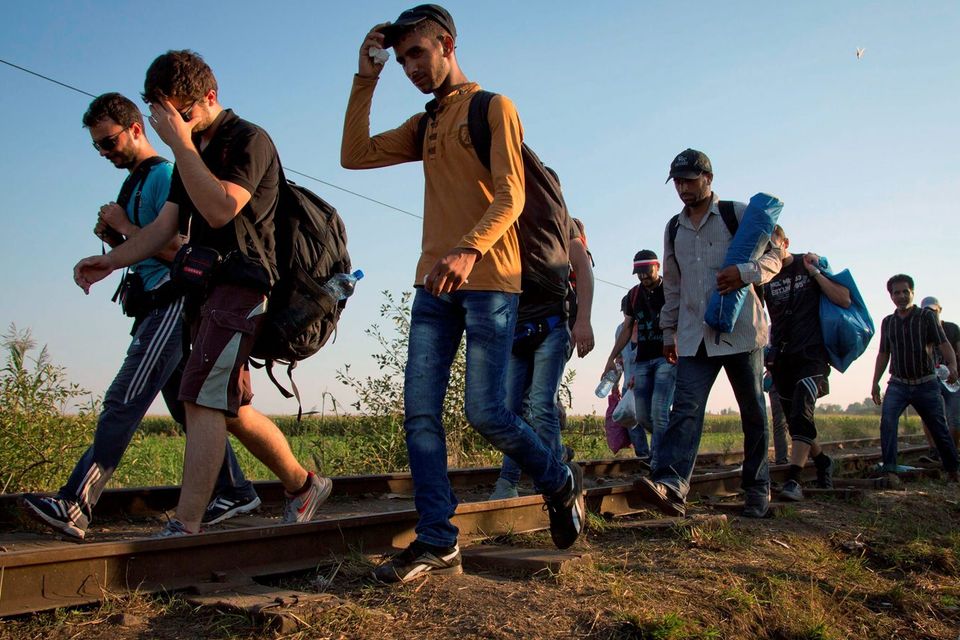 A group of migrants crosses the border walking on the railway track from Serbia into Hungary, near Roszke. AP Photo