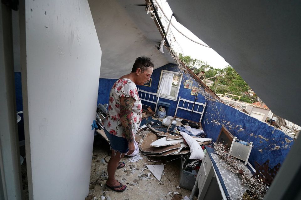 Destroyed: Gwen McGeorge looks at the hole in the roof of her home in Jefferson City, Missouri. Photo: Reuters