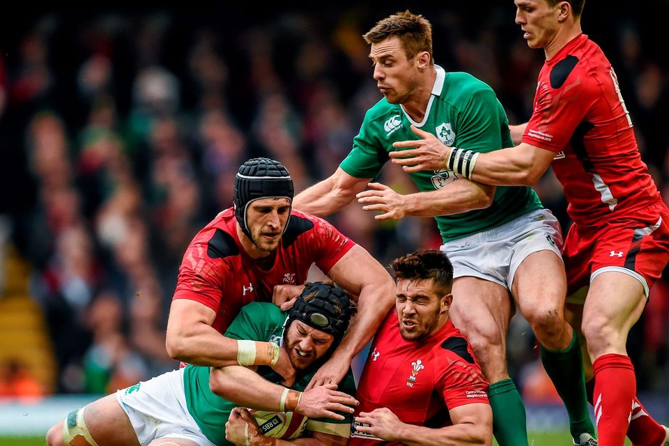 Sean O'Brien with the support of his Ireland team-mate Tommy Bowe, is tackled by Luke Charteris, left, and Rhys Webb and their Wales team-mate George North, right