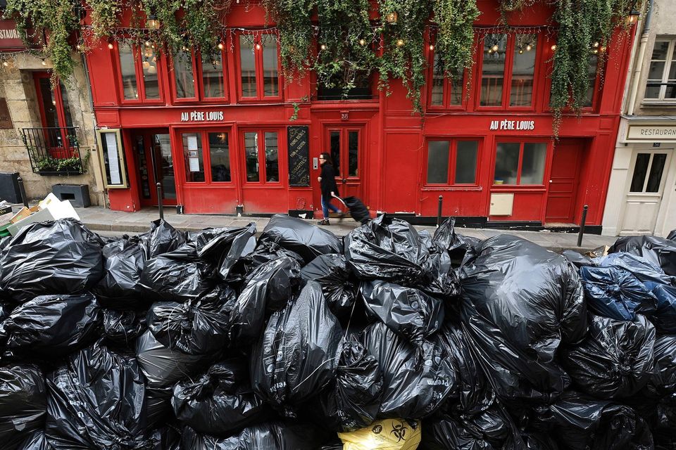Uncollected garbage piled up on a street in Paris on Monday, during an ongoing strike by sanitation workers. Photo: Aurelien Morissard/AP Photo