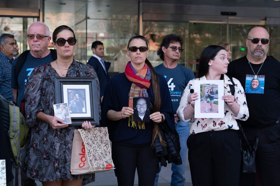 Family members holding photos of their loved ones who died in the Conception dive boat fire leave the US Federal Building in downtown Los Angeles on Thursday, May 2. Photo: Richard Vogel