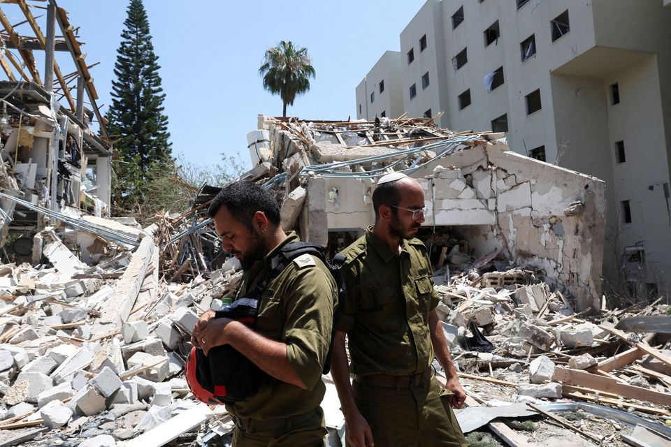 Members of Israeli forces work at an impact site following a missile attack from Iran in Tel Aviv. Photo: Reuters