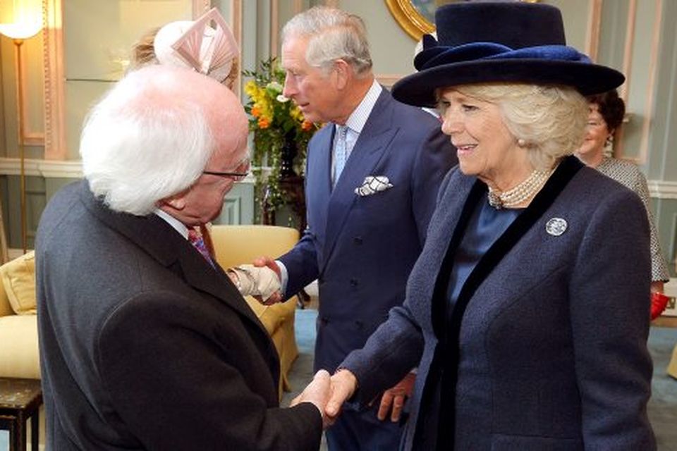 President Higgins shakes hands with the Duchess of Cornwall at the Irish Embassy in London