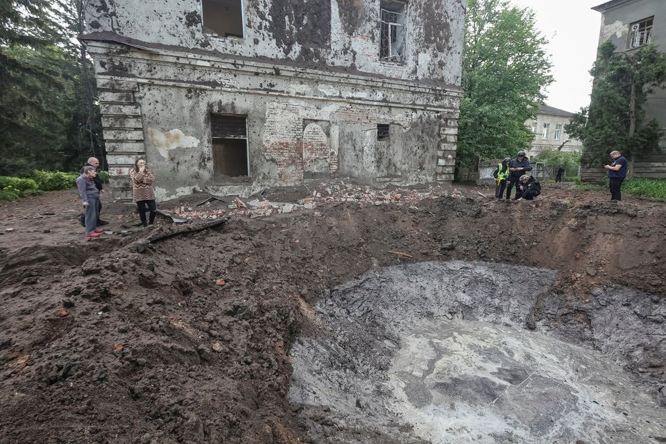 Police experts work near a crater at the site of hospital buildings damaged by a Russian missile strike in Kharkiv, Ukraine yesterday. Photo: Vyacheslav Madiyevskyy/Reuters