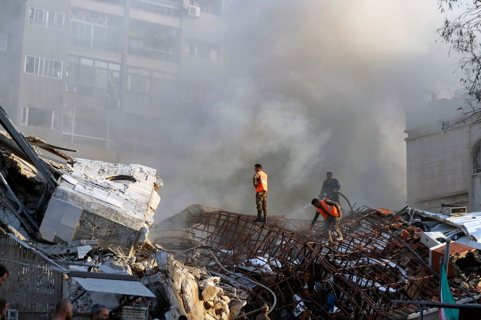 Emergency crews stand on the rubble after an Israeli airstrike destroyed the consular section of Iran's embassy in Damascus, Syria. Photo: AP