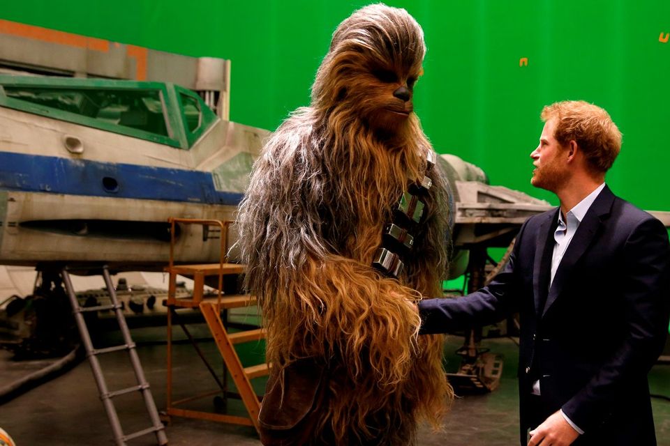 Prince Harry (R) meets Chewbacca during a tour of the Star Wars sets at Pinewood studios on April 19, 2016  in Iver Heath, England. (Photo by Adrian Dennis-WPA Pool/Getty IMages)