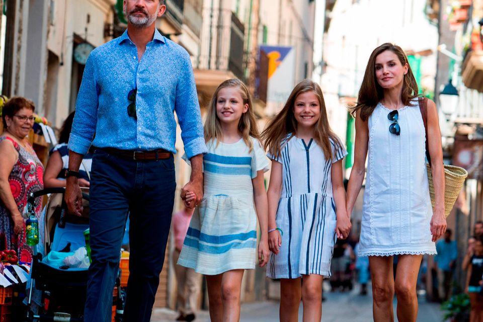 El rey de España Felipe VI (izquierda), su esposa, la reina Letizia (derecha) y sus hijas, la princesa heredera española Leonor (2 a la izquierda) y la princesa Sofía, caminan por una calle en el pueblo de Sóller en la isla de Mallorca, el 6 de agosto de 2017. / FOTO AFP / JAIME REINAJAIME REINA/AFP/Getty Images