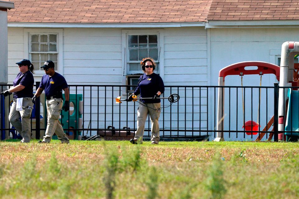 Members of the FBI Evidence Response Team use metal detectors at the playground at the site of the shooting at the First Baptist Church of Sutherland, Texas, U.S., November 6, 2017.  REUTERS/Rick Wilking