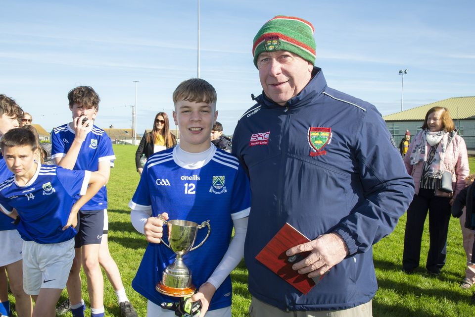Harry Murphy presents Éire Óg Greystones captain Cillian McEnerney with the Under-13 'A' football championship cup after his side defeated Ashford in Rathnew. 
