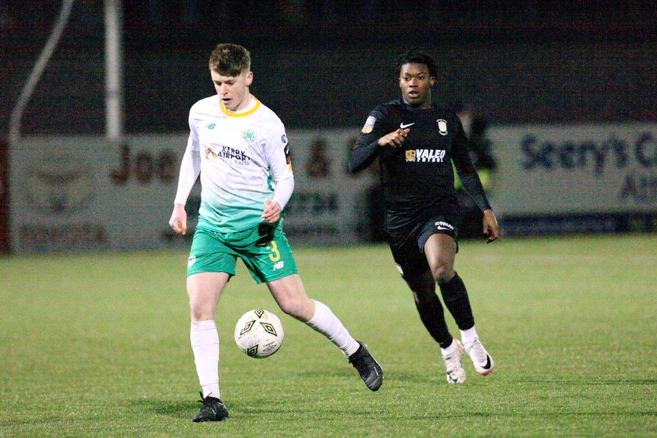 Sean O'Connell sur le ballon du Kerry FC alors que Gideon Tetteh d'Athlone Town se rapproche de lui lors de leur match de première division à Athlone