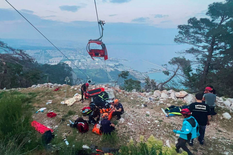 Rescue team members work with passengers of a cable car transportation system outside Antalya, Turkey. Photo: AP