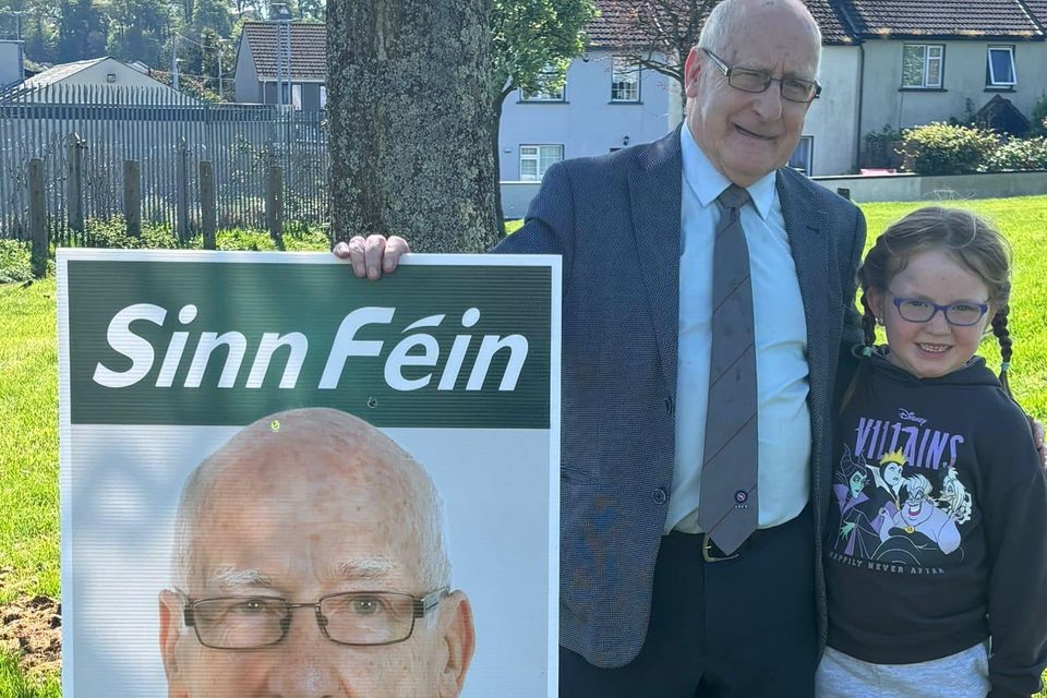 Cllr Davy Hynes with a young supporter and one of his new election posters.