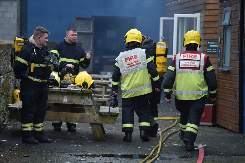 Members of the Fire Brigade with breathing apparatus attend to a fire at Jack's Tavern in Camolin on Monday. Pic: Jim Campbell