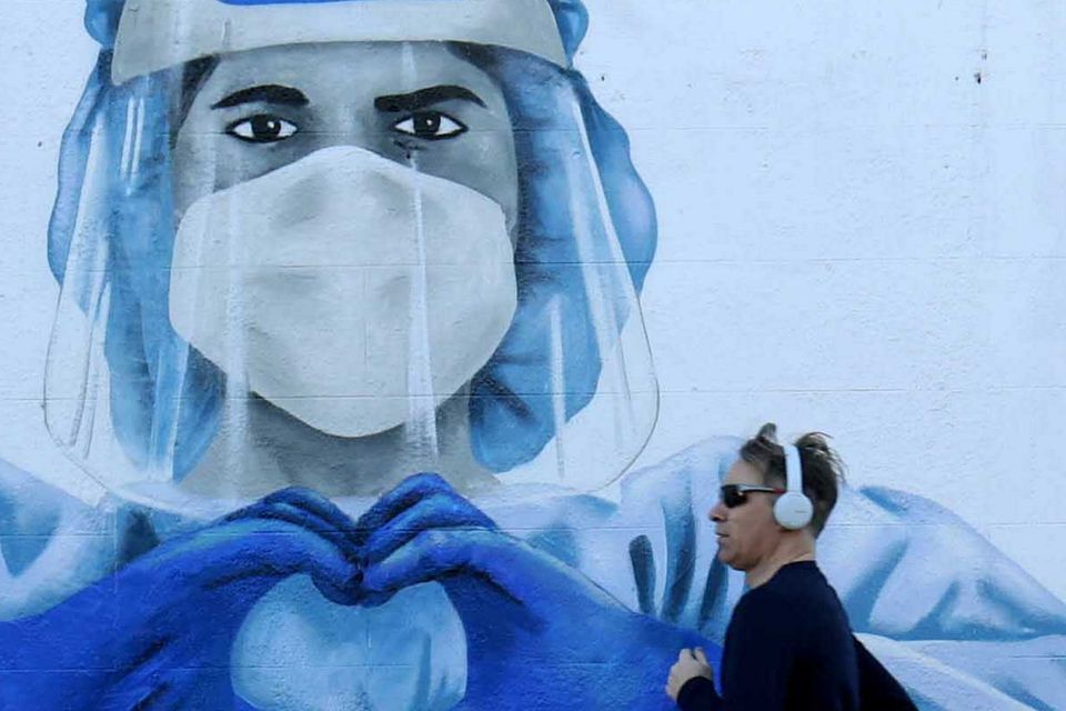 A jogger passes a mural in Harold's Cross in Dublin depicting a nurse during the pandemic. Photo: Sam Boal/RollingNews.ie