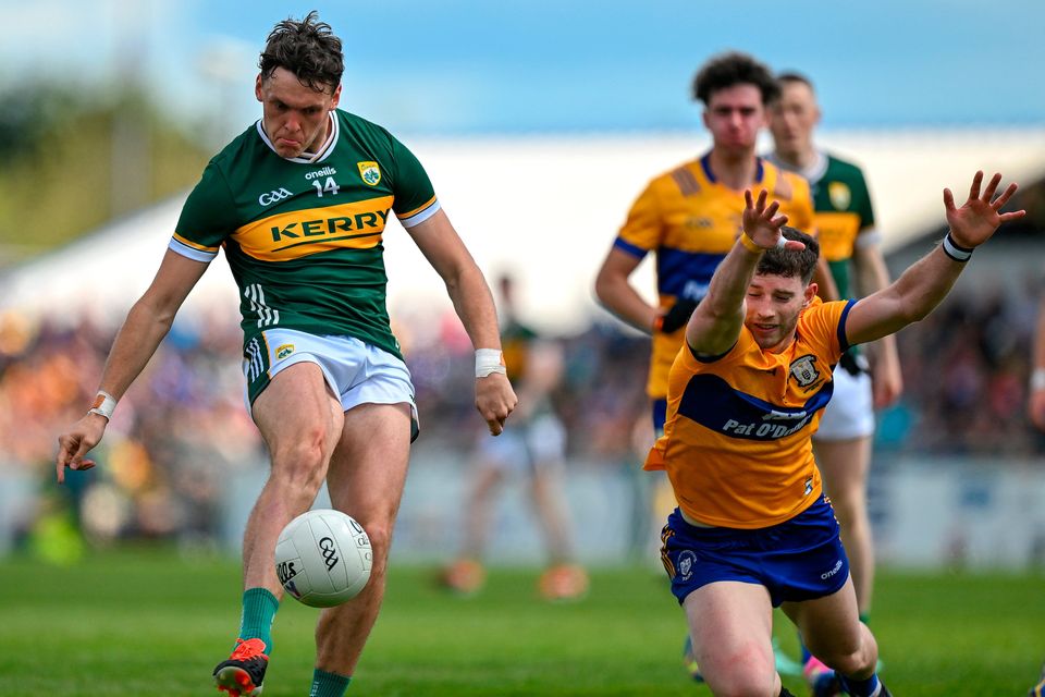 David Clifford of Kerry kicks a point despite the efforts of Ronan Lanigan of Clare during the Munster SFC final at Cusack Park in Ennis, Clare. Photo by Brendan Moran/Sportsfile