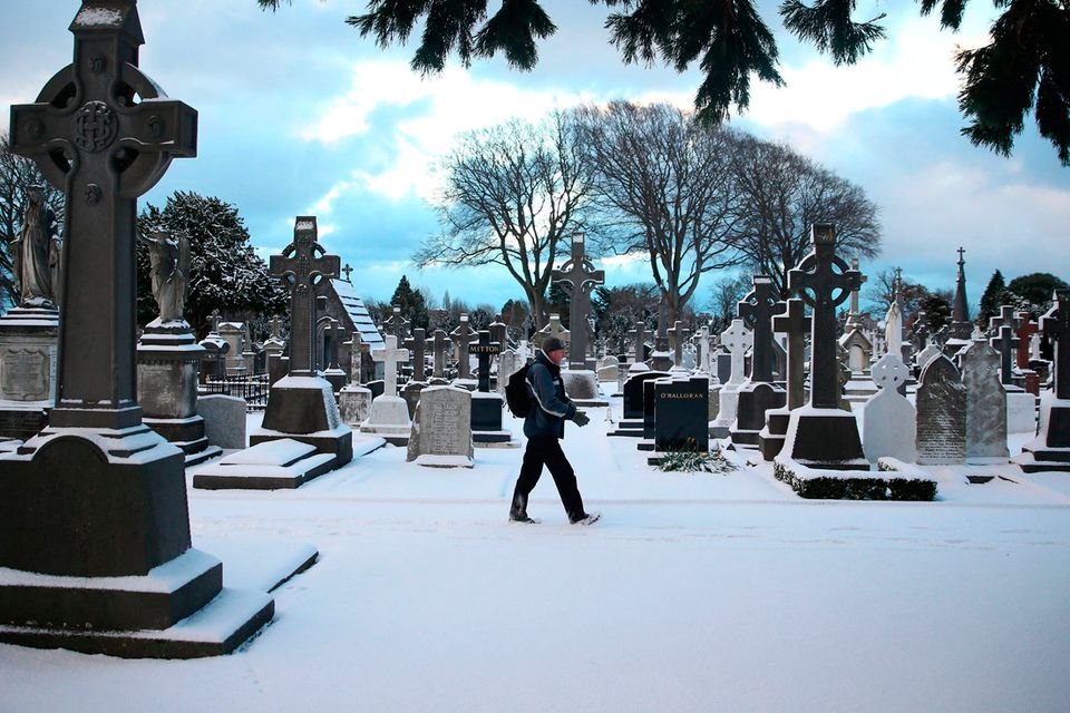 A man on his way to work walks through Glasnevin cemetery in Dublin as heavy snow has caused more misery for travellers overnight. Photo: Brian Lawless/PA Wire