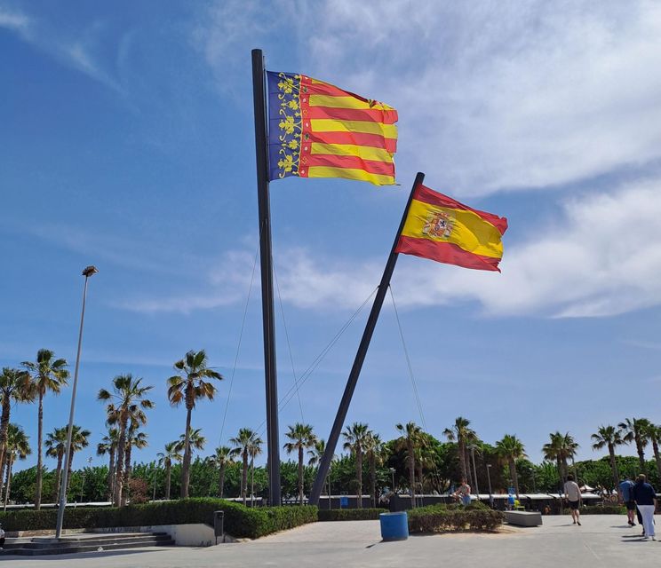 The Valencian flag flies alongside the Spanish flag on the beach in Valencia.