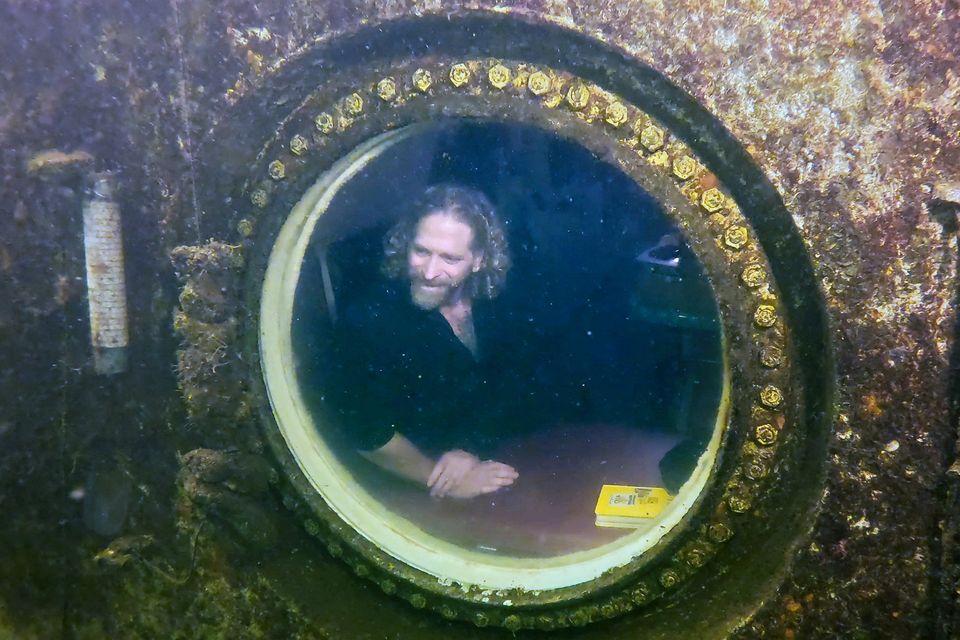 Dr Joseph Dituri peers out of a porthole inside the Jules’ Undersea Lodge. Photo: Reuters