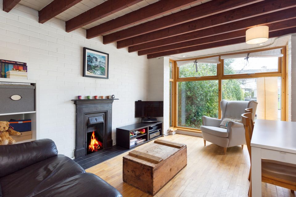 The living room with exposed beams and floor-to-ceiling window