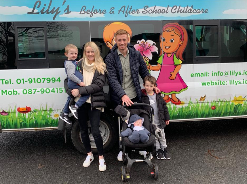 The Doyle family alongside a minibus bearing the name of the childcare company which Doyle co-owns