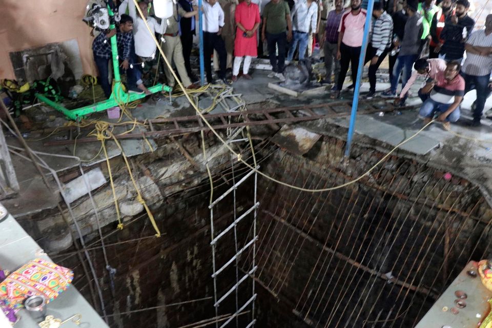 People stand around a structure built over an old temple well that collapsed Thursday as a large crowd of devotees gathered for the Ram Navami Hindu festival in Indore, India. AP